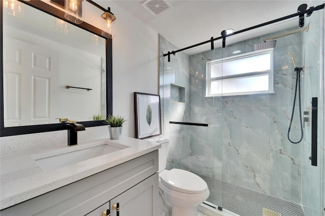 bathroom with vanity, a shower with door, and toilet