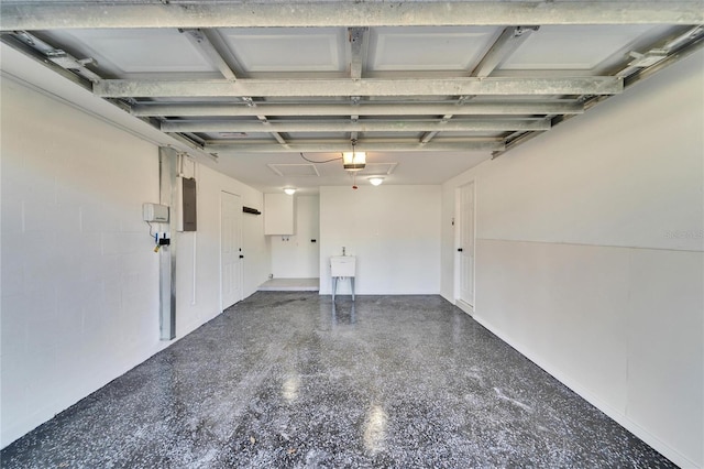 garage with a garage door opener, electric panel, and sink