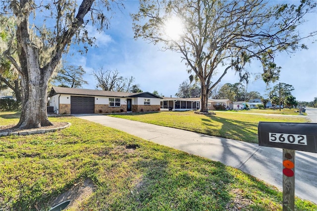 ranch-style home with a garage and a front lawn