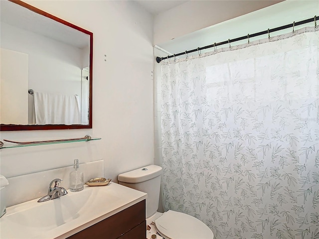 bathroom featuring vanity, curtained shower, and toilet