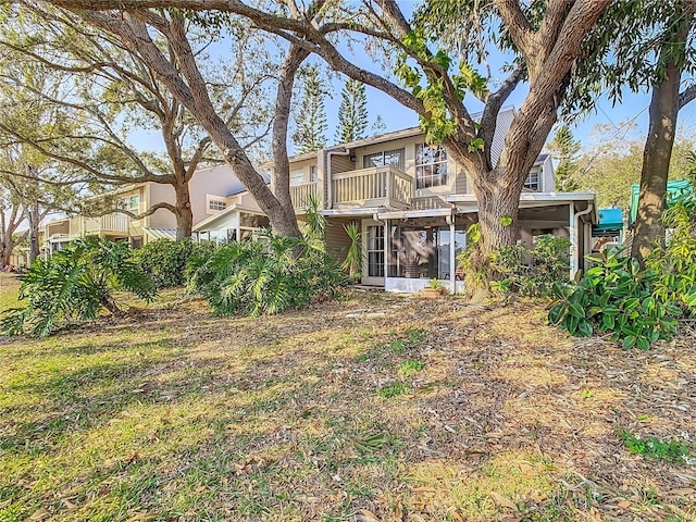 rear view of property with a balcony and a sunroom