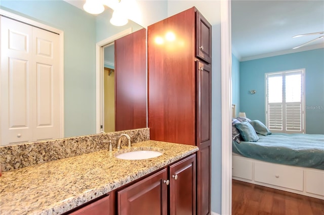 bathroom with hardwood / wood-style flooring, crown molding, and vanity