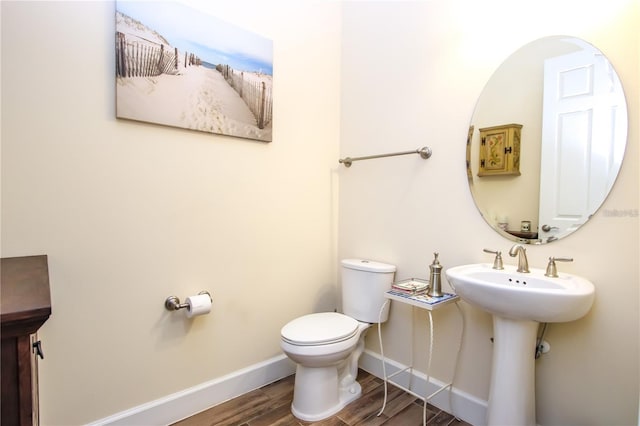 bathroom with hardwood / wood-style floors and toilet