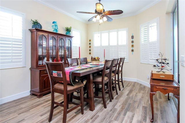 dining space with ceiling fan, ornamental molding, and light wood-type flooring