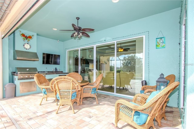 view of patio with area for grilling, ceiling fan, and exterior kitchen