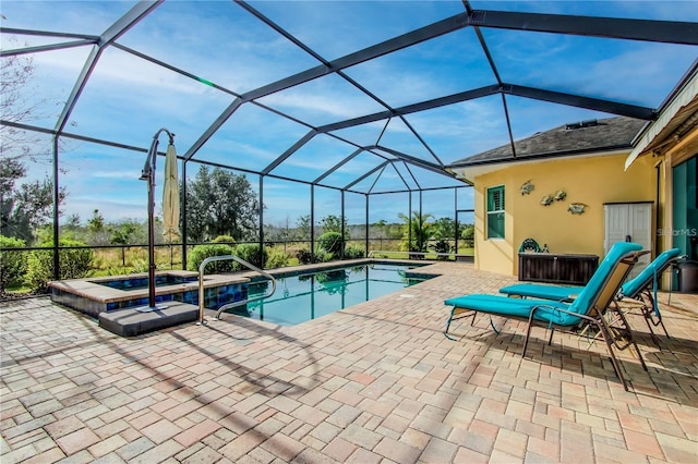 view of swimming pool with an in ground hot tub, a lanai, and a patio