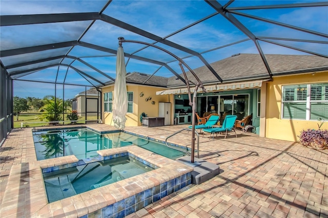 view of pool with an in ground hot tub, glass enclosure, and a patio area