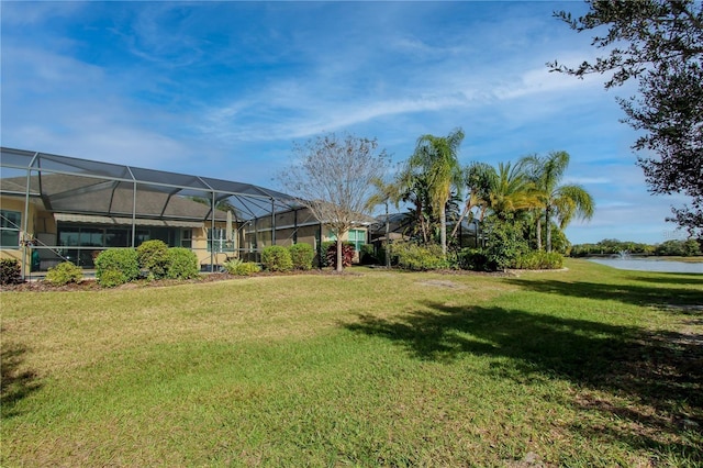 view of yard with a water view and a lanai