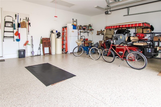 garage featuring a garage door opener and white refrigerator