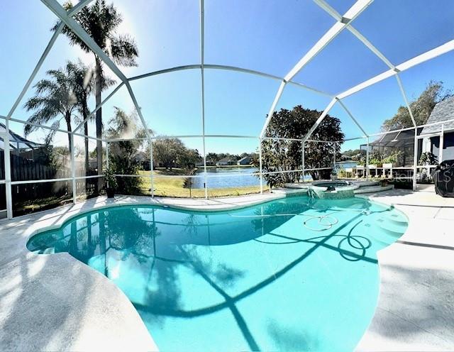 view of pool featuring a lanai, a patio, and an in ground hot tub