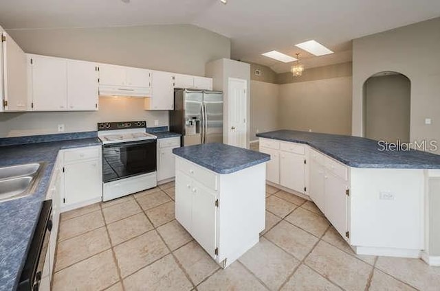 kitchen with white cabinets, a center island, stainless steel fridge, and electric stove