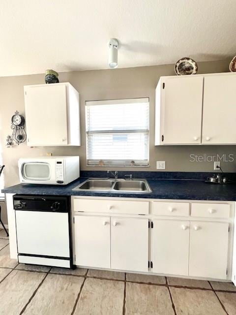 kitchen with white appliances, sink, a textured ceiling, and white cabinets