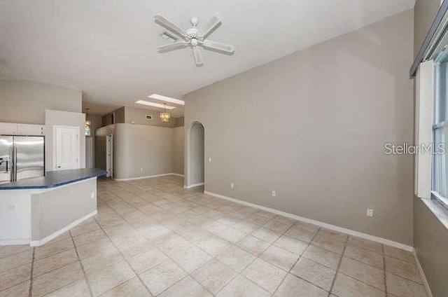 kitchen with stainless steel refrigerator with ice dispenser, ceiling fan, white cabinetry, and light tile patterned floors