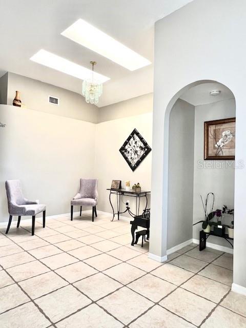 living area with light tile patterned floors and a chandelier