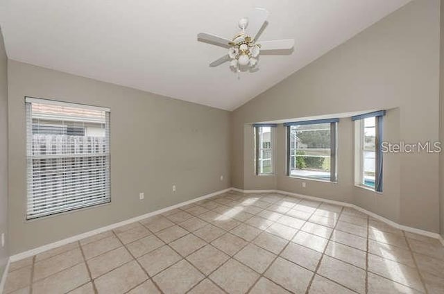 empty room with light tile patterned flooring, ceiling fan, and high vaulted ceiling