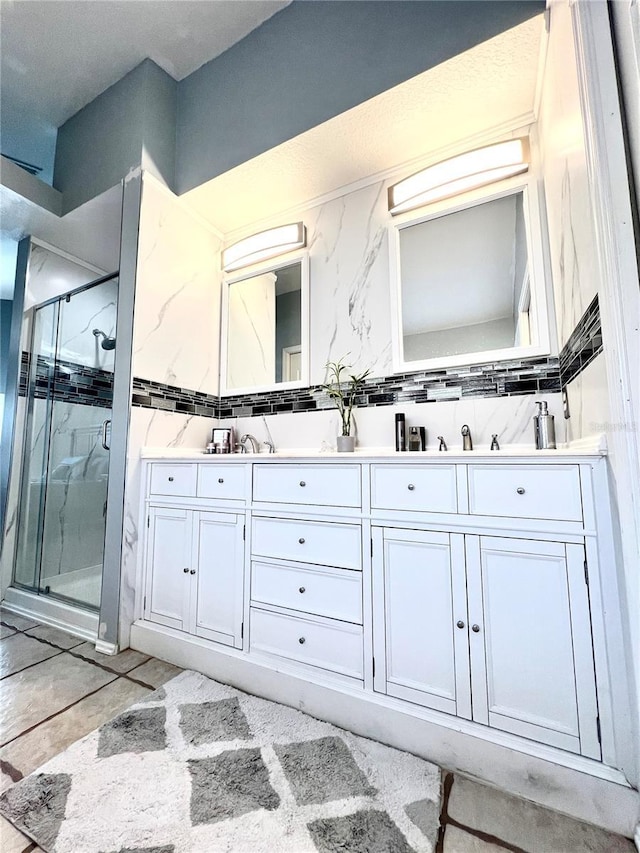 bathroom with a shower with door, vanity, and tasteful backsplash