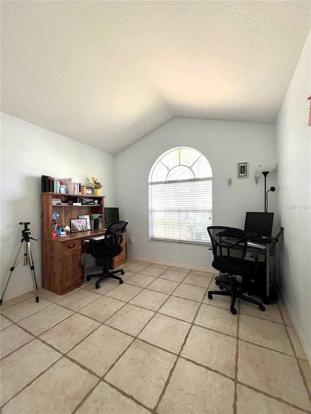 tiled office featuring vaulted ceiling and a textured ceiling