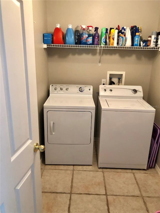 clothes washing area with washing machine and clothes dryer and light tile patterned floors