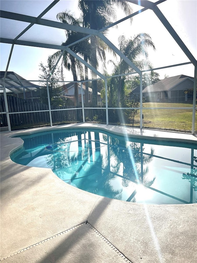 view of swimming pool with glass enclosure