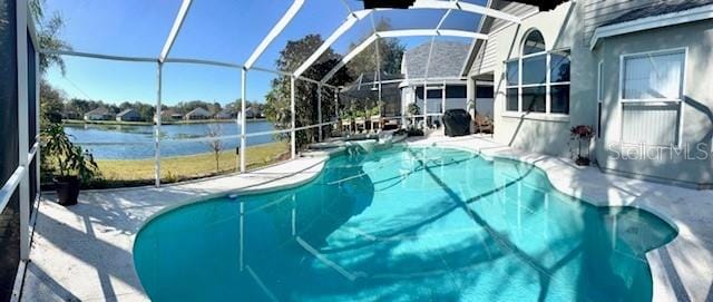 view of pool with a patio, a water view, and glass enclosure