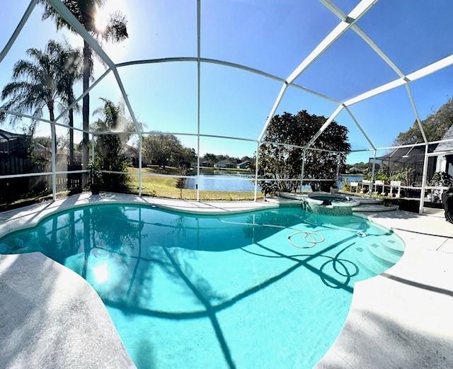 view of pool featuring a water view, a patio, an in ground hot tub, and glass enclosure