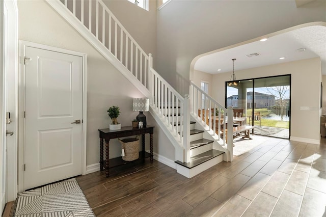 stairway with a water view and a high ceiling