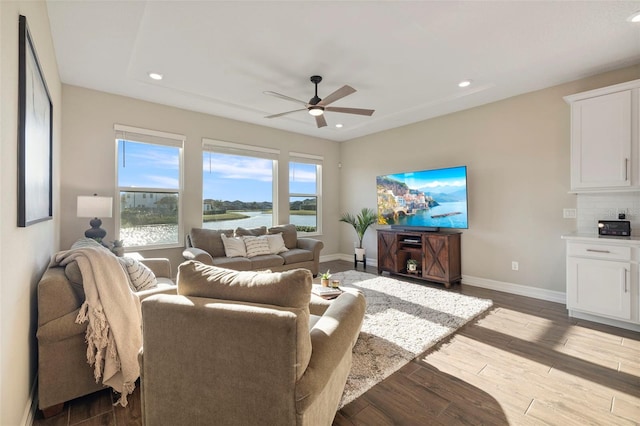 living room featuring light hardwood / wood-style flooring and ceiling fan