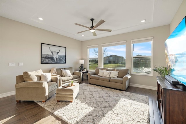 living room featuring dark wood-type flooring and ceiling fan