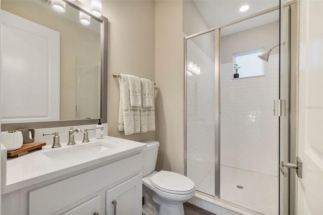 bathroom featuring an enclosed shower, vanity, and toilet