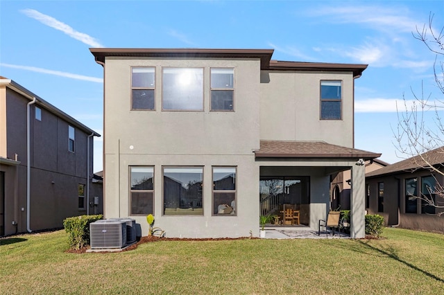 rear view of property featuring cooling unit and a lawn