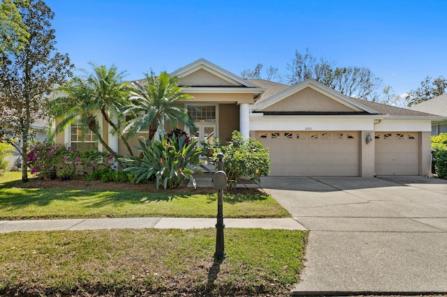 view of front facade featuring stucco siding, an attached garage, concrete driveway, and a front lawn