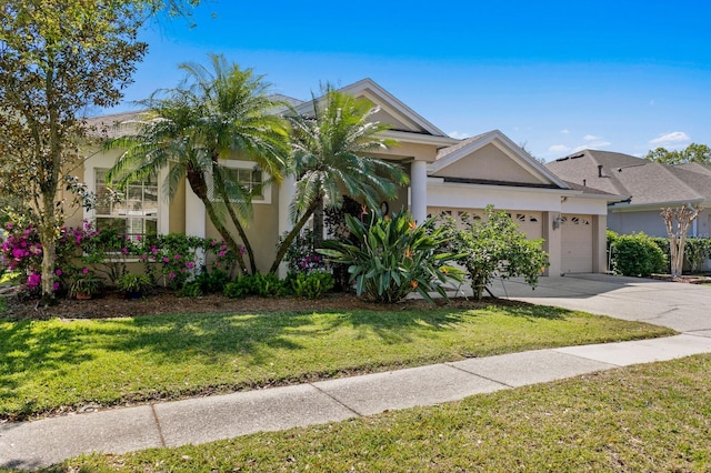 view of front of home with a garage, a front lawn, concrete driveway, and stucco siding