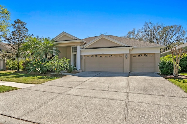 view of front of house featuring stucco siding, a garage, and driveway