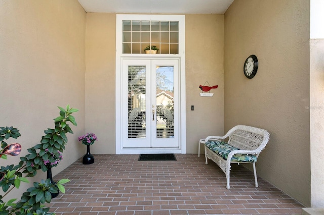 entrance to property featuring stucco siding and french doors