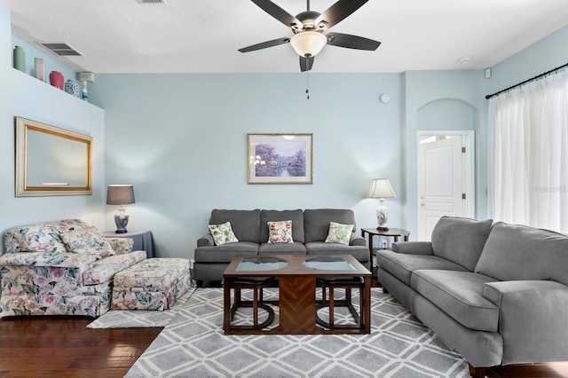 living room with visible vents, ceiling fan, and wood finished floors