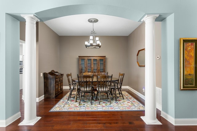 dining area featuring decorative columns, baseboards, visible vents, and wood finished floors