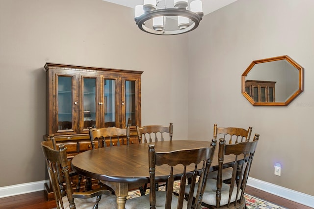 dining space with a chandelier, baseboards, and wood finished floors