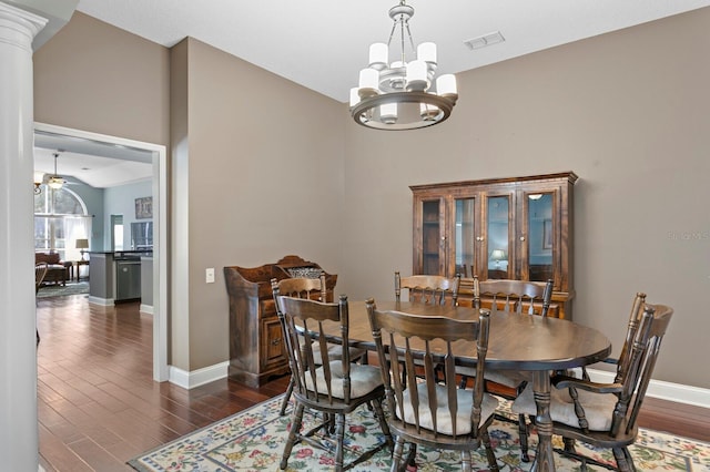 dining room featuring an inviting chandelier, dark wood-type flooring, baseboards, and visible vents