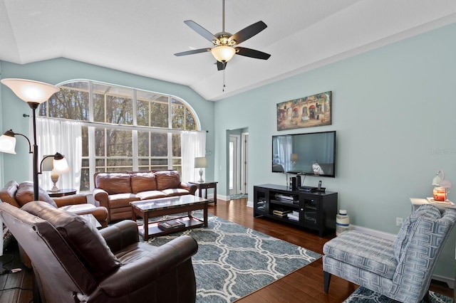 living area with ceiling fan, wood finished floors, baseboards, and vaulted ceiling