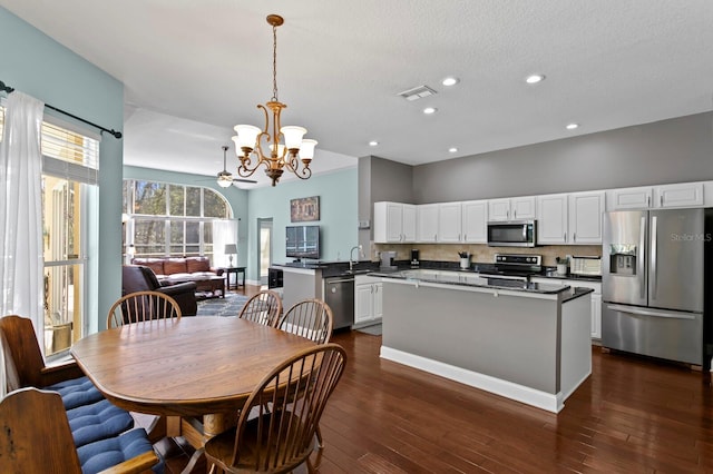 dining space with dark wood-style floors, visible vents, baseboards, an inviting chandelier, and recessed lighting