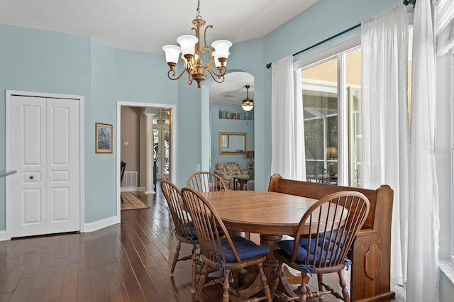 dining room with dark wood finished floors, ceiling fan with notable chandelier, and baseboards