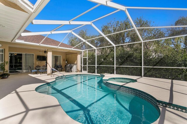 view of pool with a ceiling fan, a lanai, a patio area, and a pool with connected hot tub