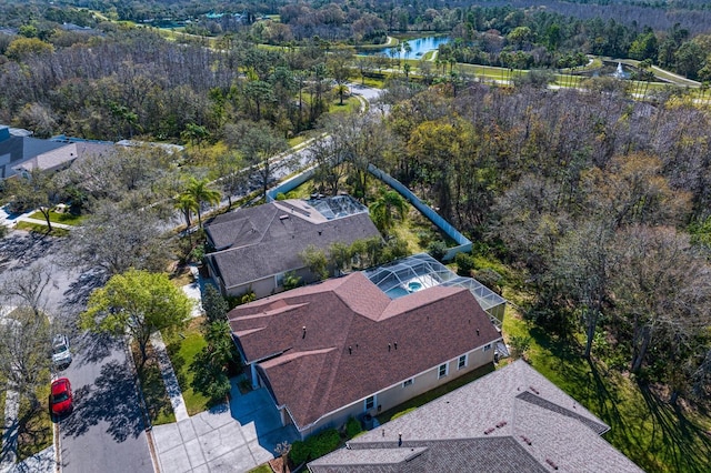 birds eye view of property with a wooded view and a water view