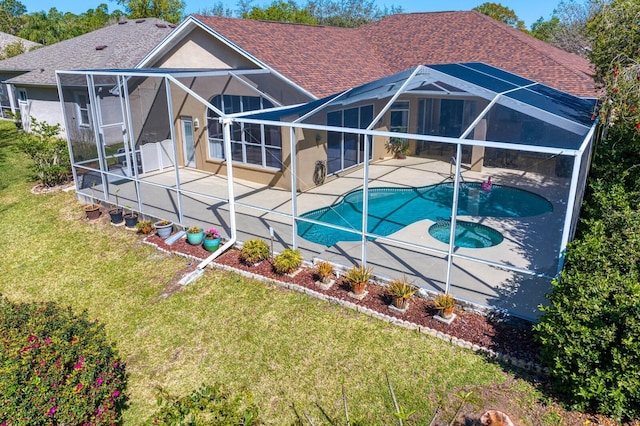 rear view of property with stucco siding, a yard, roof with shingles, a lanai, and a patio area