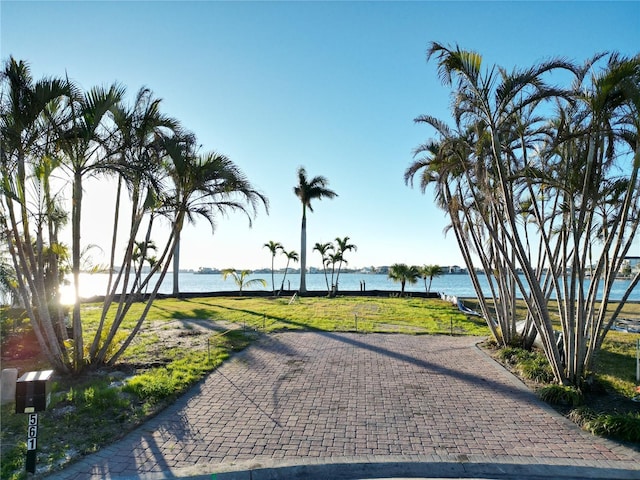 surrounding community featuring a water view and a lawn