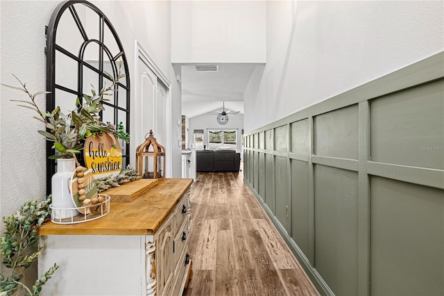 hall with hardwood / wood-style flooring and lofted ceiling