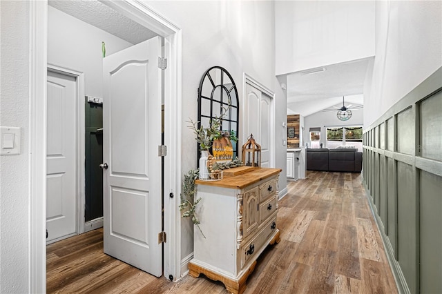 hall with hardwood / wood-style flooring and vaulted ceiling