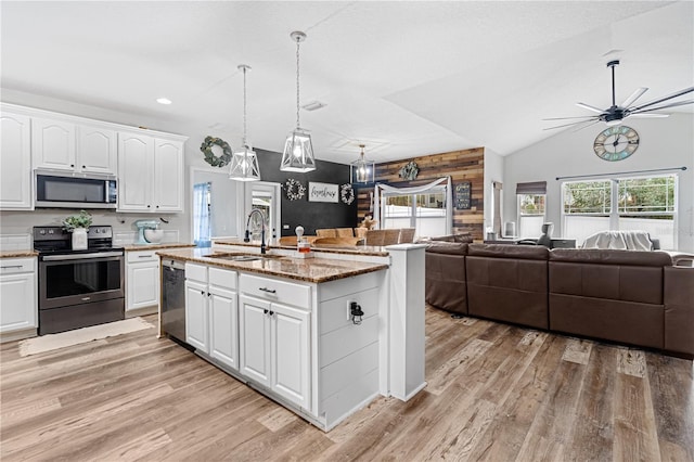 kitchen featuring sink, light hardwood / wood-style flooring, appliances with stainless steel finishes, a kitchen island with sink, and white cabinets