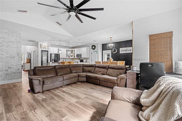 living room with light hardwood / wood-style flooring, high vaulted ceiling, and ceiling fan