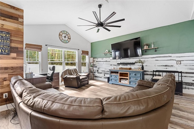 living room featuring hardwood / wood-style flooring, high vaulted ceiling, ceiling fan, and wood walls